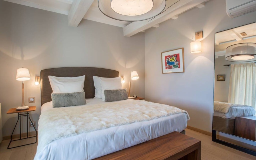 Chambre avec grand lit blanc et tableau coloré à La Bastide Saint Georges