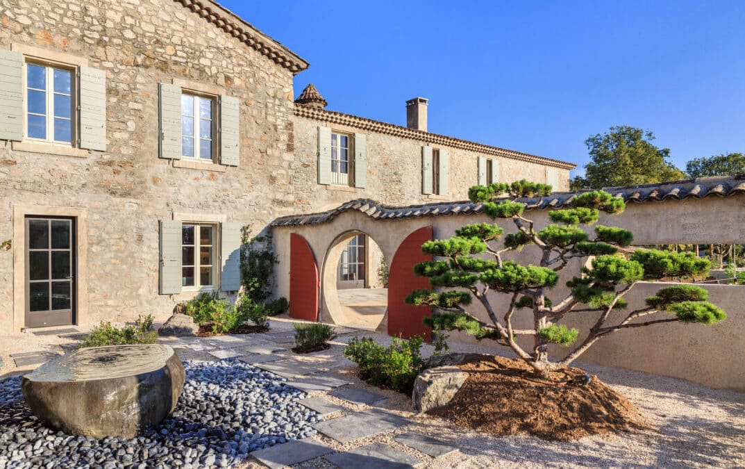 Façade en pierre et jardin japonisant avec pin taillé au Château de Berne, dans le Var