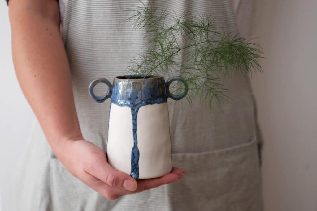 Vase en céramique blanc et bleu à anses avec feuillage, création d’Ici l’Atelier