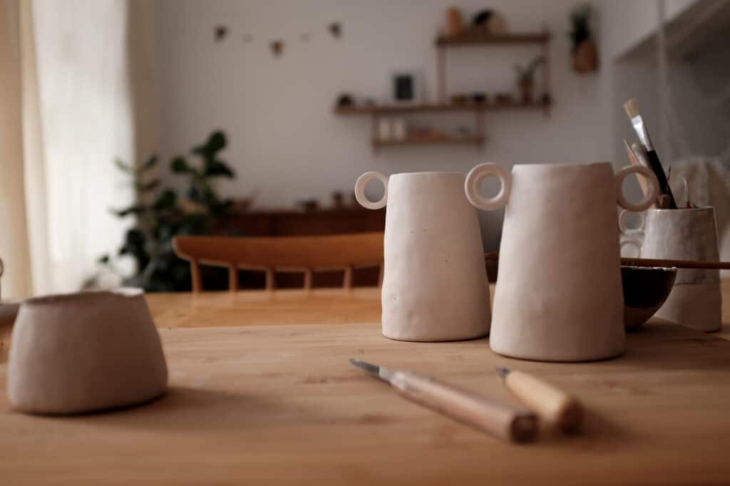 Pichets et pots en céramique brute sur un établi de l’atelier Ici l’Atelier, à La Ciotat
