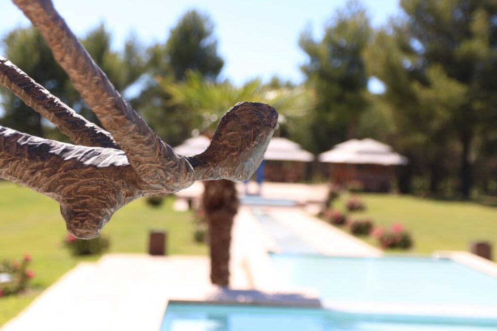 Sculpture en bronze devant la piscine et les parasols de l’Hôtel du Castellet