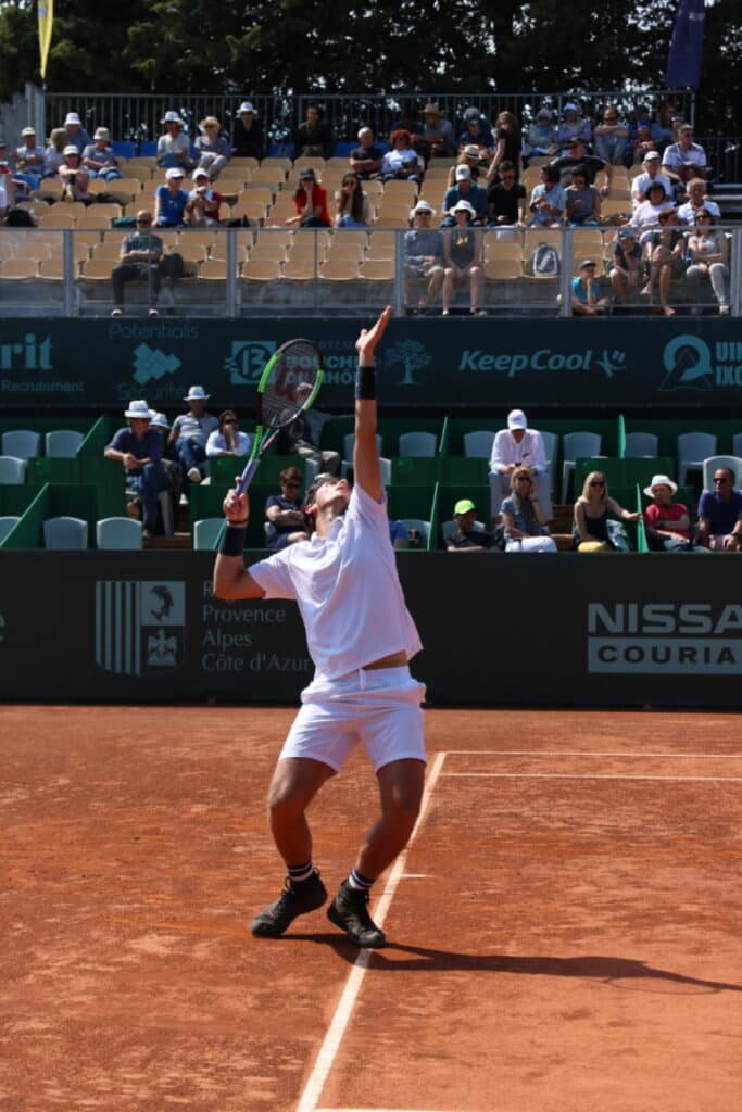 Joueur au service sur la terre battue de l’Open du Pays d’Aix