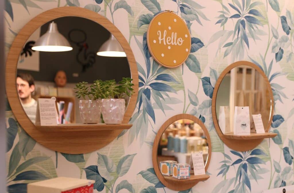 Étagères rondes et papier peint fleuri chez La Toque Cuivrée