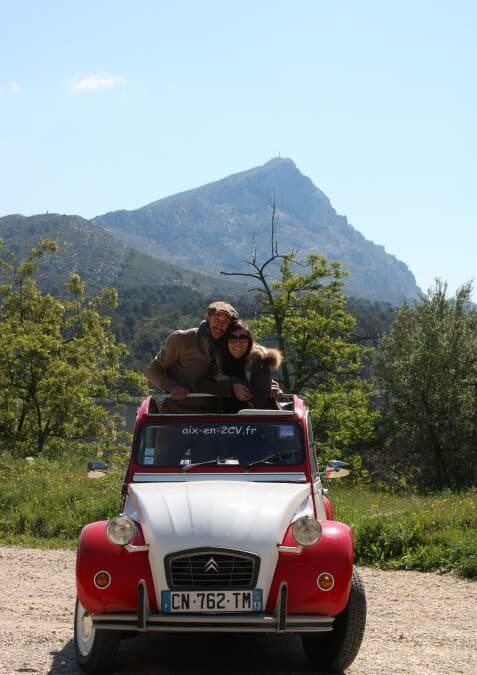 2CV rouge et blanche d’Aix en 2CV devant la montagne Sainte-Victoire