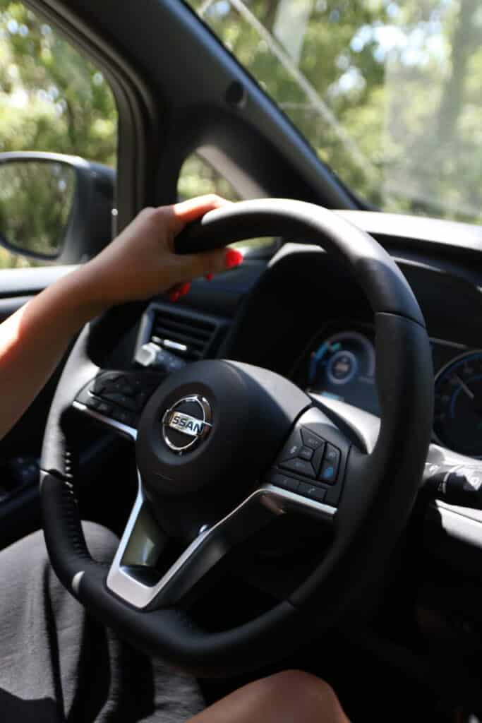 Mains sur le volant d’une Nissan Leaf électrique