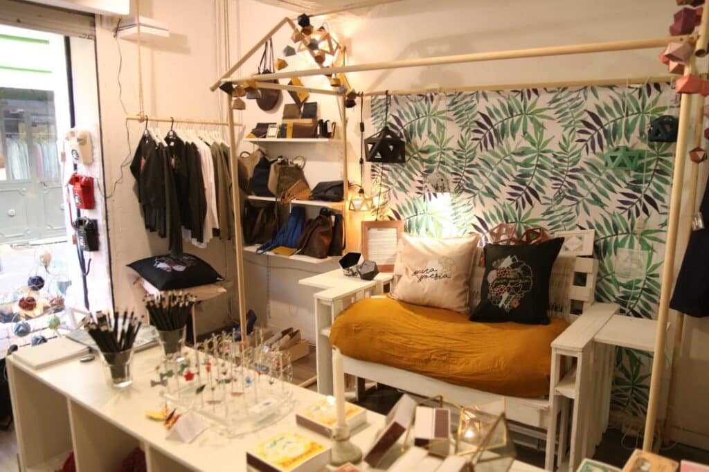 Coin boutique du concept store Aix and Co avec banc, coussins et portants de créateurs
