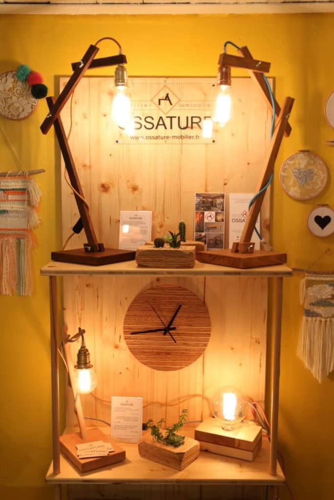 Stand de créateur avec horloge en bois et lampes à ampoule chez Aix and Co