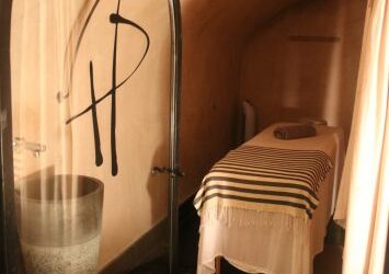 Cabine de soin avec table et serviette rayée au Hammam des Prêcheurs