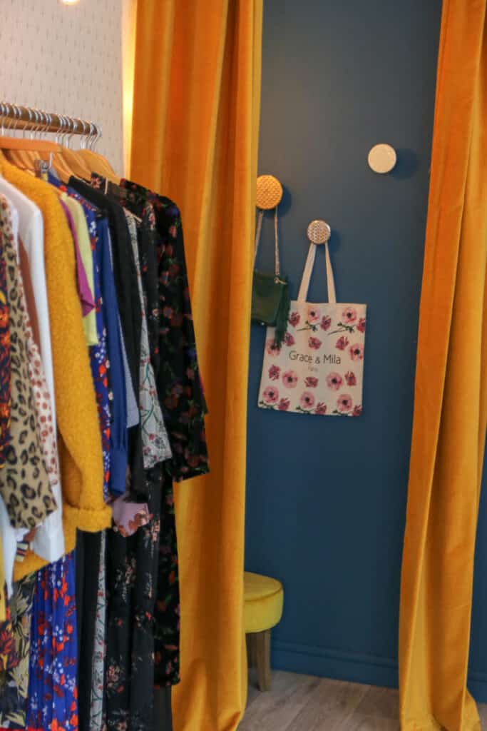 Cabine d’essayage aux rideaux moutarde et vêtements colorés chez Abbie & Lou