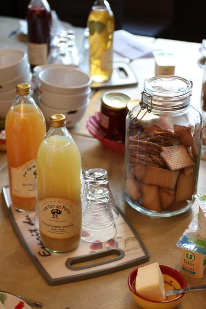 Jus de fruits, bocal de biscuits et fromage au petit déjeuner de l’Oustaou du Luberon