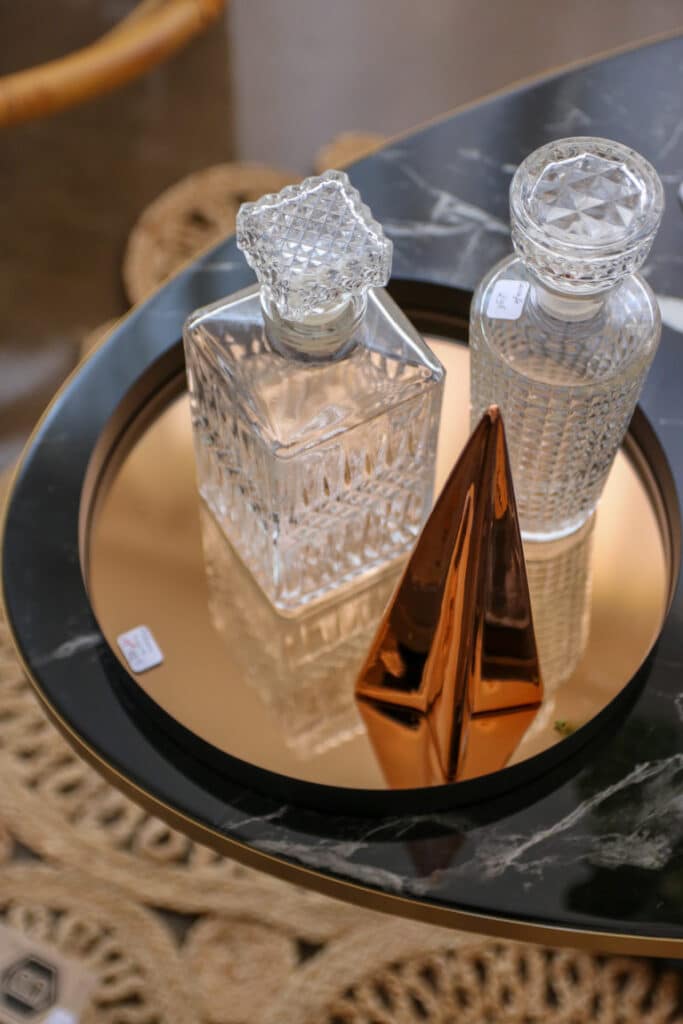Carafes en cristal et cône cuivré sur un plateau en marbre, à La Nostra Deco