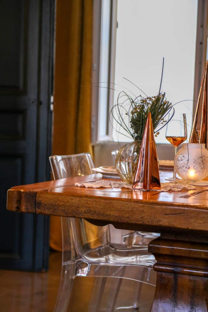 Table en bois, chaises transparentes et objets cuivrés à La Nostra Deco, à Salon-de-Provence