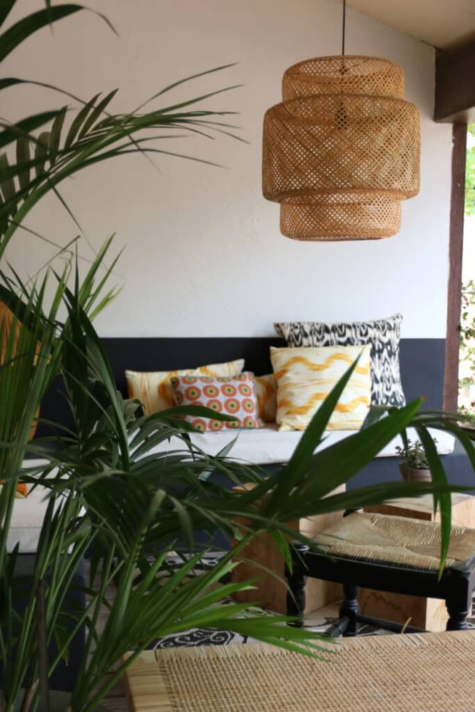 Coin salon avec plantes et suspension en rotin à l’hôtel Victor