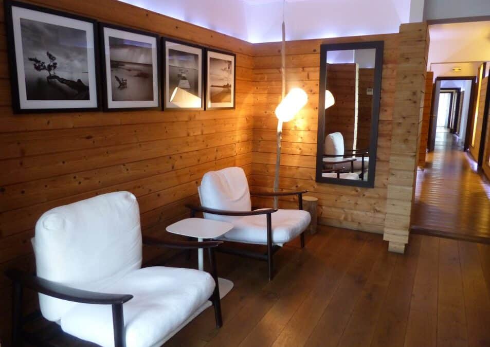 Coin salon avec fauteuils blancs et photos encadrées au spa Baumanière