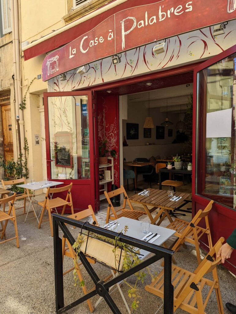 Devanture rouge et terrasse de La Case à Palabres, rue Pontis à Salon-de-Provence
