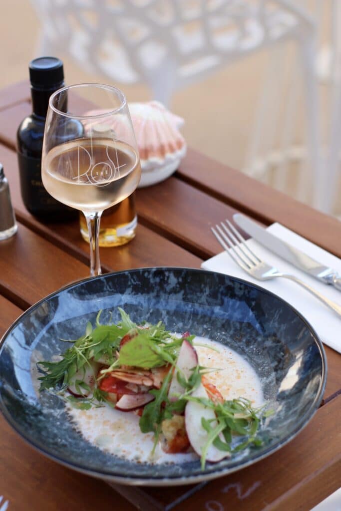 Assiette de poisson et verre de vin blanc à l’Hôtel & Restaurant Rosé Thé, à La Ciotat